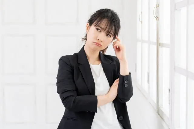 右上を向いて思案する女性