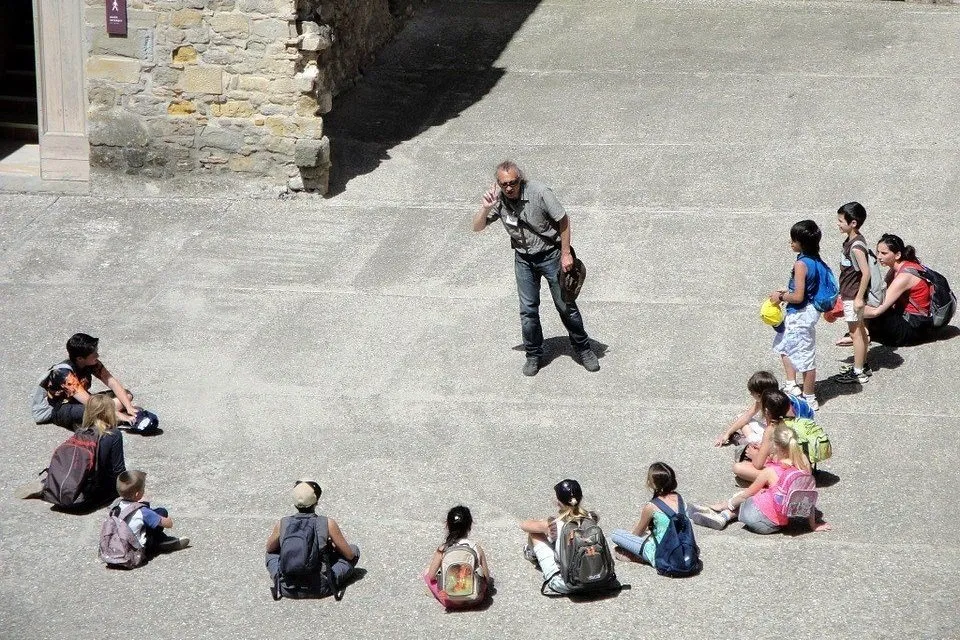 教師を中心に半円形に座る子どもたち